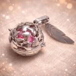 Bola de grossesse élégant et symbolique, conçu pour accompagner la future maman tout au long de sa grossesse. Ce bijou raffiné se compose d’un pendentif sphérique ajouré renfermant une bille sonore délicate, émettant un doux tintement apaisant à chaque mouvement. Porté sur un long collier, le bola repose naturellement sur le ventre arrondi et crée un lien sonore rassurant entre la maman et son bébé.