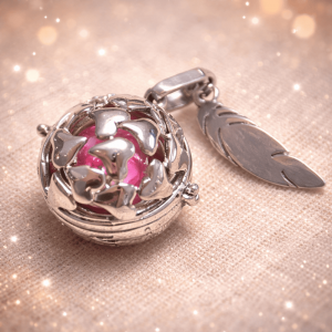 bola de grossesse 1 Bola de grossesse élégant et symbolique, conçu pour accompagner la future maman tout au long de sa grossesse. Ce bijou raffiné se compose d’un pendentif sphérique ajouré renfermant une bille sonore délicate, émettant un doux tintement apaisant à chaque mouvement. Porté sur un long collier, le bola repose naturellement sur le ventre arrondi et crée un lien sonore rassurant entre la maman et son bébé.